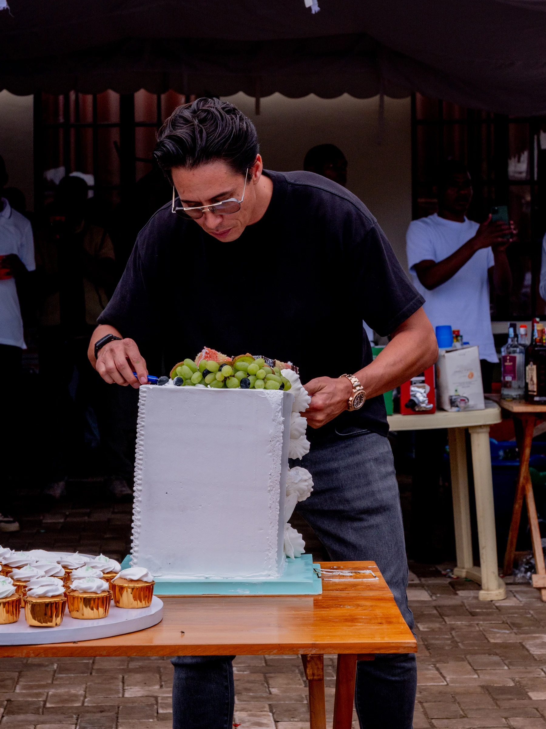 Guest preparing a celebration cake outdoors